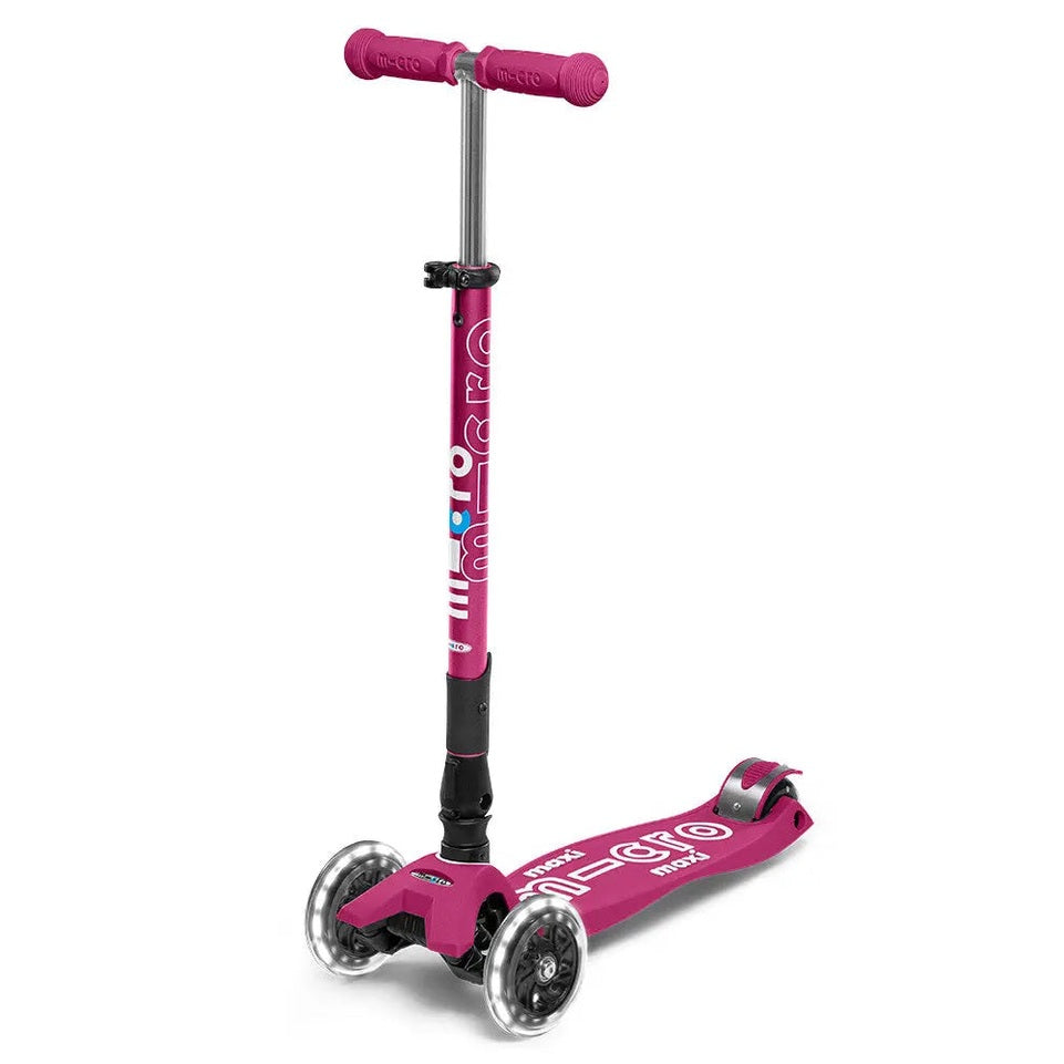 Micro Maxi Foldable Deluxe LED Scooter pink with three wheels and adjustable handlebar, shown ready to ride.