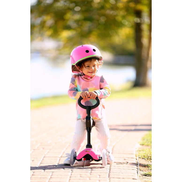 Micro Mini 3In1 Deluxe Scooter Pink; child rider wearing a pink helmet on a pink scooter