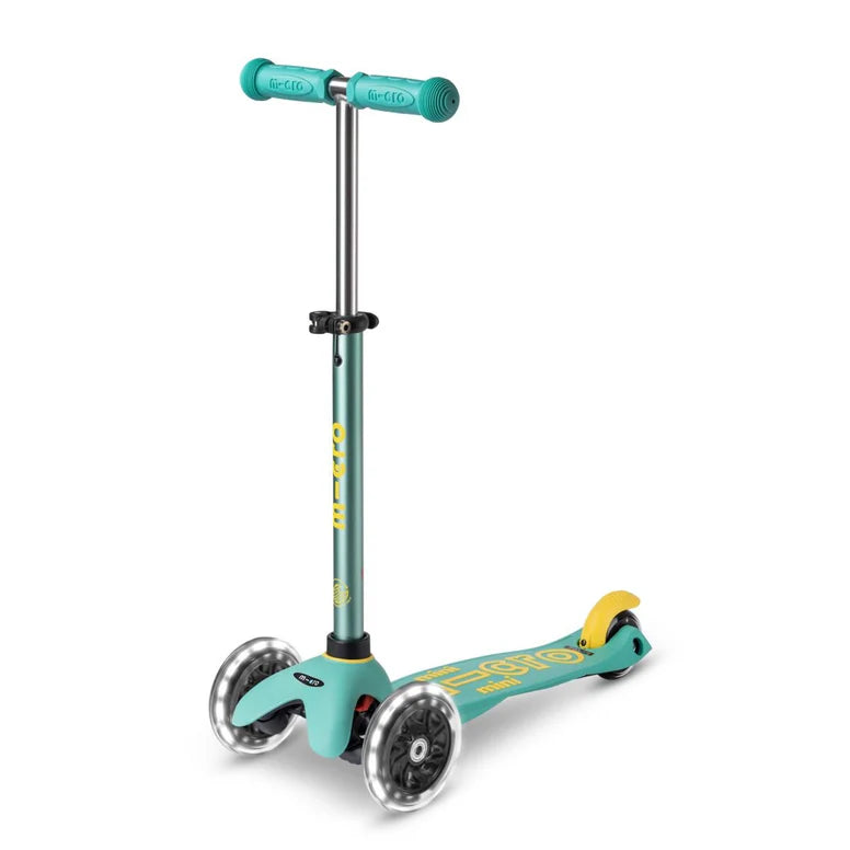 Micro Mini Deluxe Eco Scooter Green three-wheel kick scooter by MICRO with teal handlebars and yellow rear fender