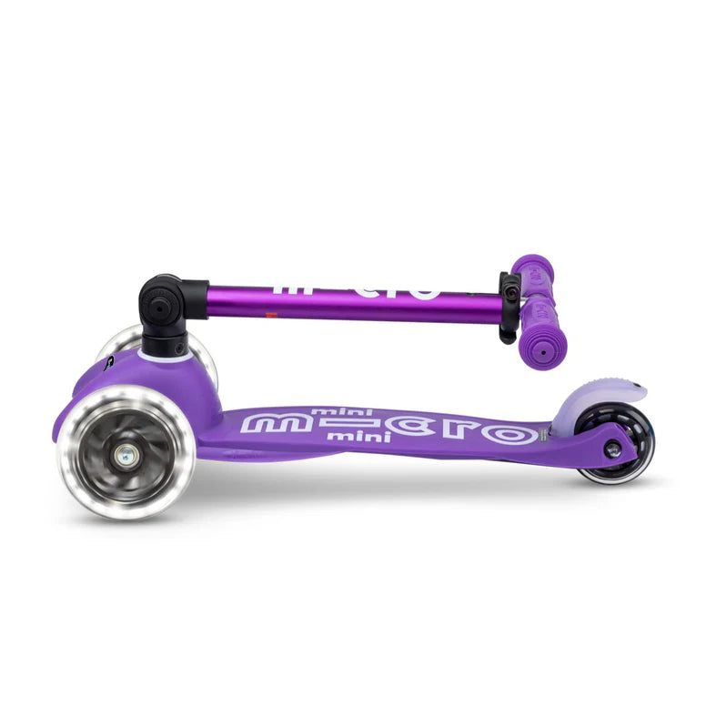 Micro Mini Deluxe Foldable LED Scooter, purple deck and handlebars with the stem folded for compact storage.