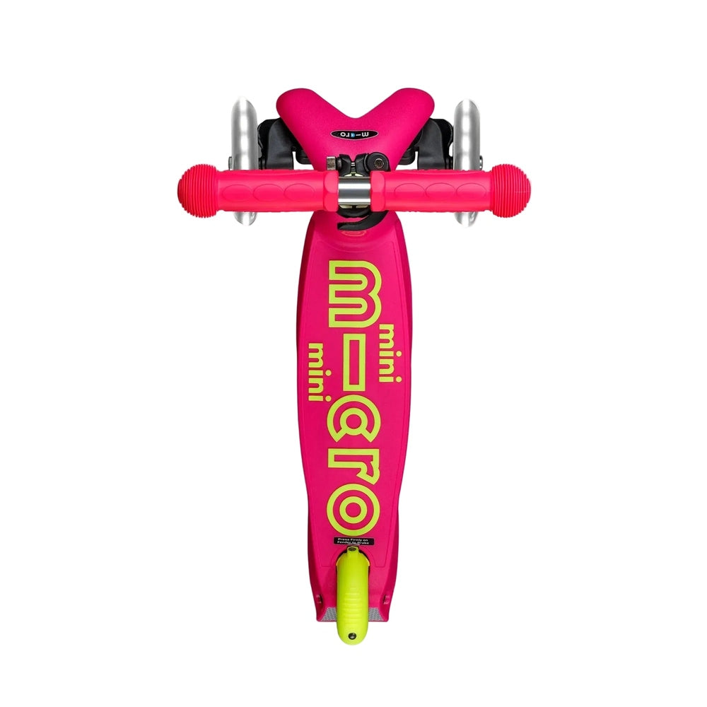 Top-down view of a pink and neon yellow Micro Mini scooter showing the deck, handlebar, and three clear wheels on a white background.