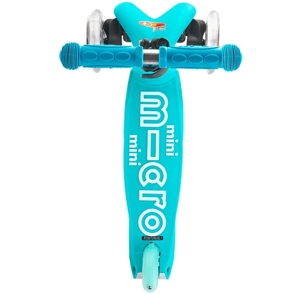 Micro Mini Deluxe Scooter in teal blue with blue grip handlebars and small wheels on a bright deck.
