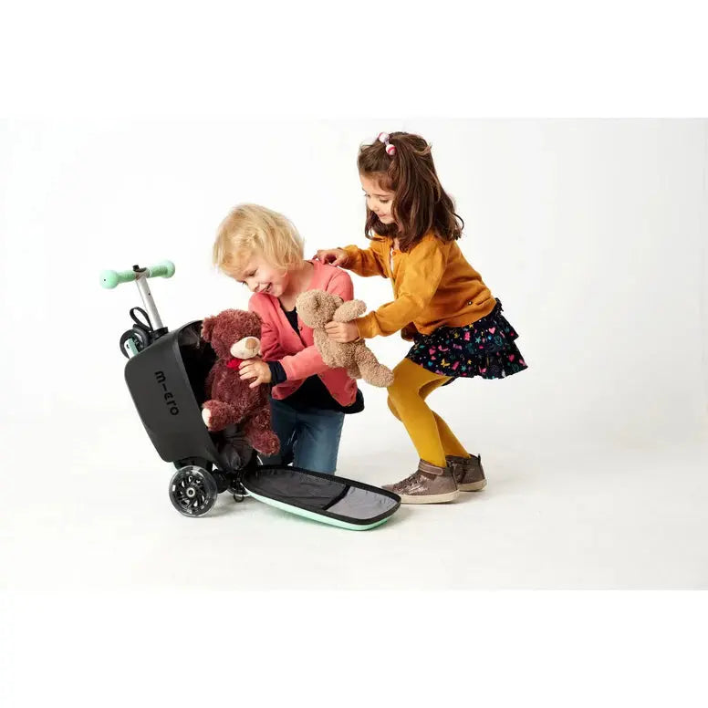Micro Scooter Junior Luggage Mint suitcase with mint accents, two kids play with teddy bears beside it as it opens.