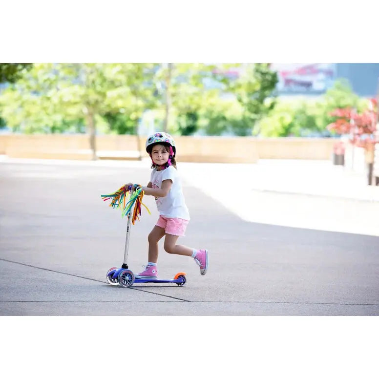 Micro Scooter Streamers: a child rides a purple MICRO scooter with colorful tassels on the handlebar.