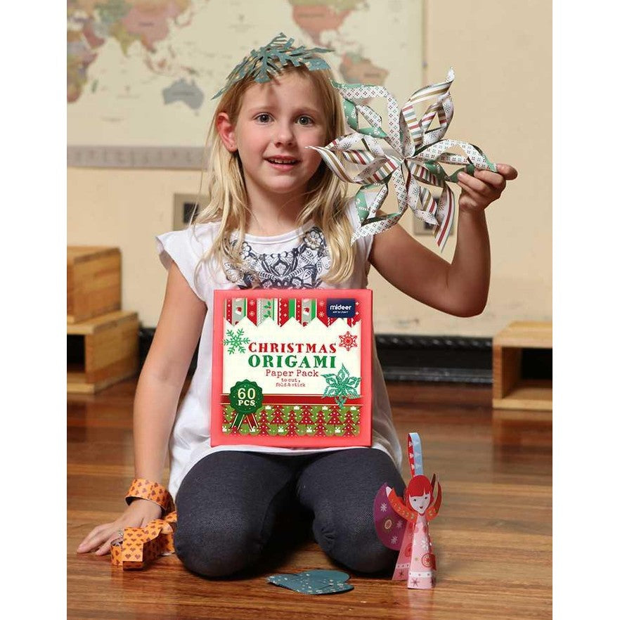Mideer Christmas Origami Paper Pack, 60 pieces, held by a girl crafting festive paper stars