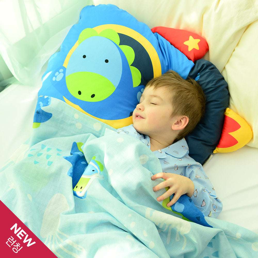 Milo & Gabby kids pillowcase in blue dinosaur print with a sleeping child on blue bedding