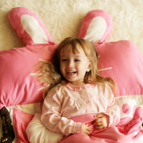 MILO & GABBY kids sleeping bag in pink; smiling child wrapped in cozy sleeping bag with bunny ear accents.