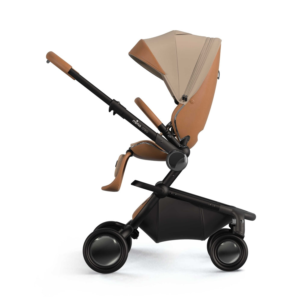 Mima Creo stroller in tan leather and beige canopy on a black frame with large wheels.