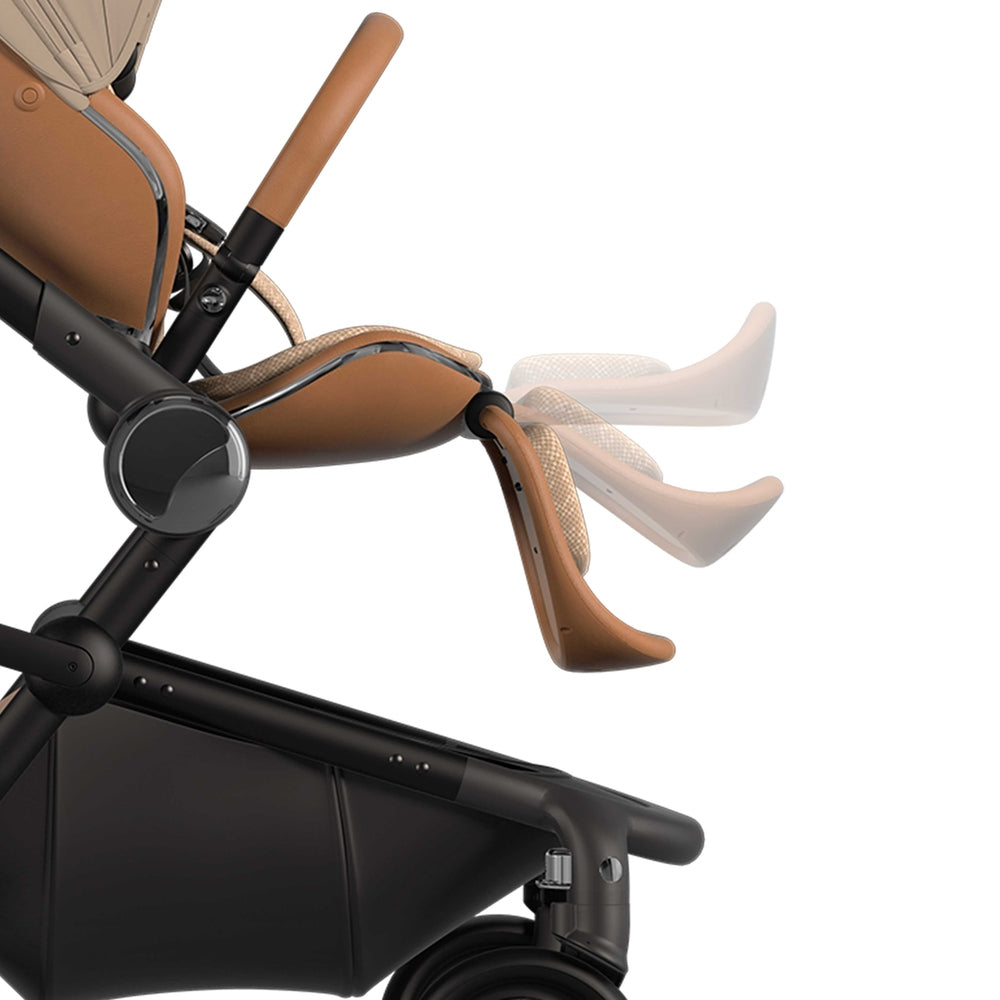 Mima Creo Stroller in tan leather seat with beige harness, showing adjustable leg rest in use.