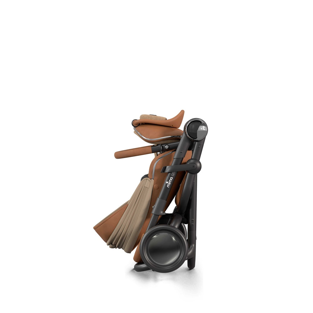 Mima Creo Stroller folded for compact storage, tan leather seat and canopy, black frame and wheels