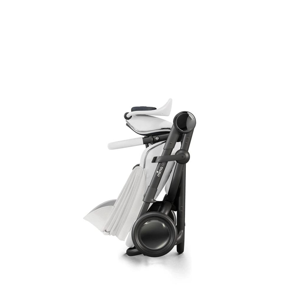 Mima Creo stroller folded compactly in gray frame with white seat, showing its easy-fold design.