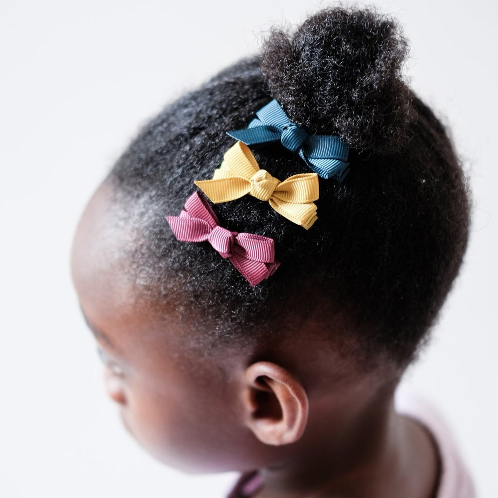 Mimi & Lula Mini Florence Clips trio ribbon bow hair accessories in teal, yellow, and pink on dark hair