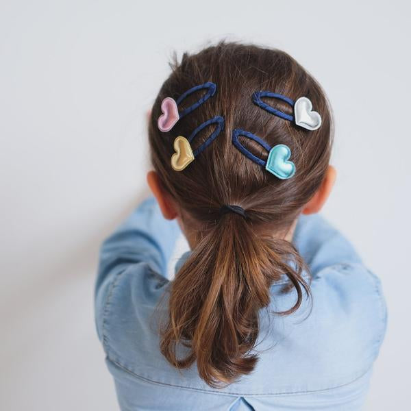 Mimi & Lula Party Hearty Clips five pastel heart clips on blue elastics in a child's ponytail
