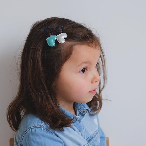Mimi & Lula Party Hearty Clips: turquoise and white heart hair clips on a young girl