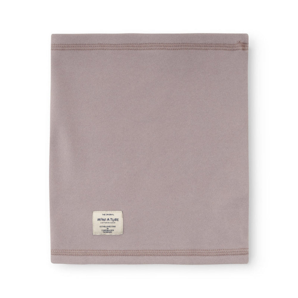 Mini A Ture Matakon neckwarmer in quail purple, soft fabric with brand label.