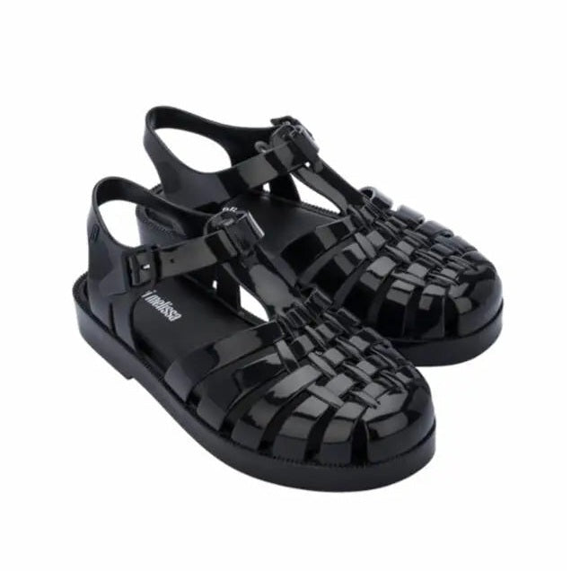 MINI MELISSA Child Possession Sandal Black, glossy rubber with woven front and buckle ankle strap buckled.