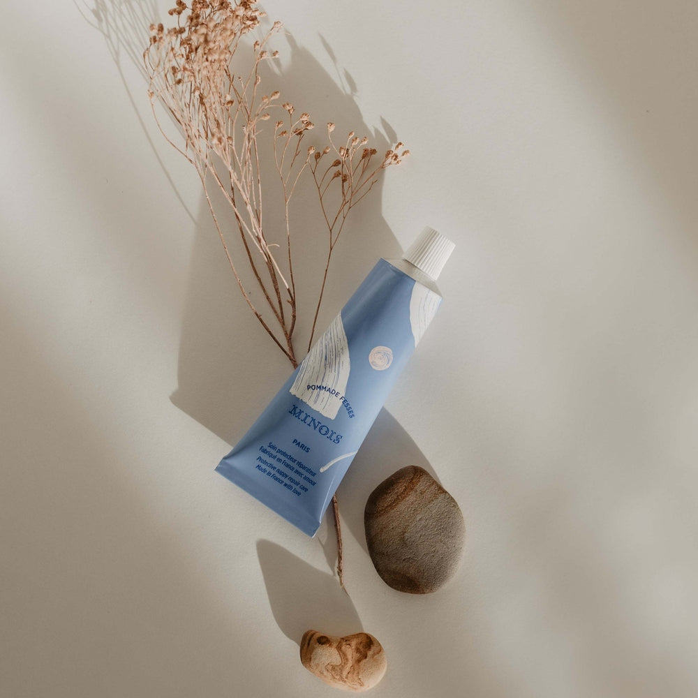 Minois Paris Diaper Cream 50 ml blue tube with white cap on a minimalist flat lay.