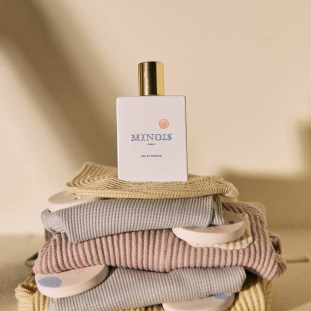 MINOIS PARIS Eau de Senteur 50 ml white bottle with gold cap atop pastel striped towels