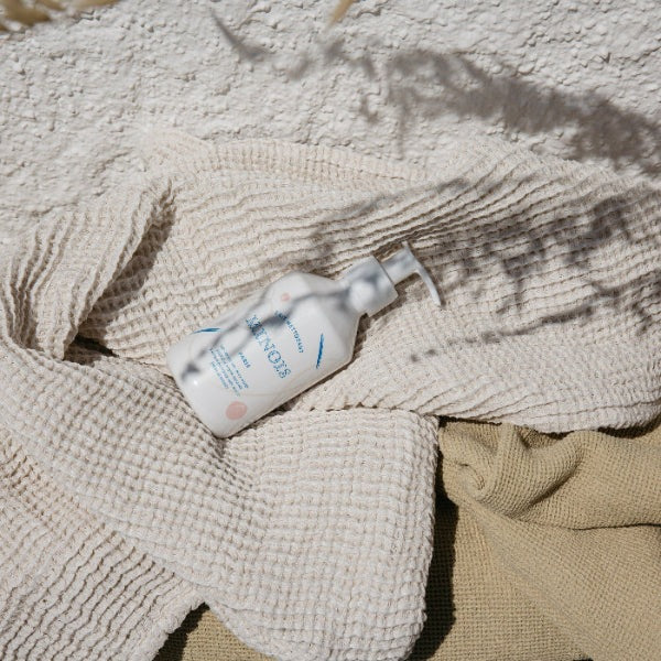 Minois Paris Facial Cleansing Milk bottle with pump on beige towels, 250 ml