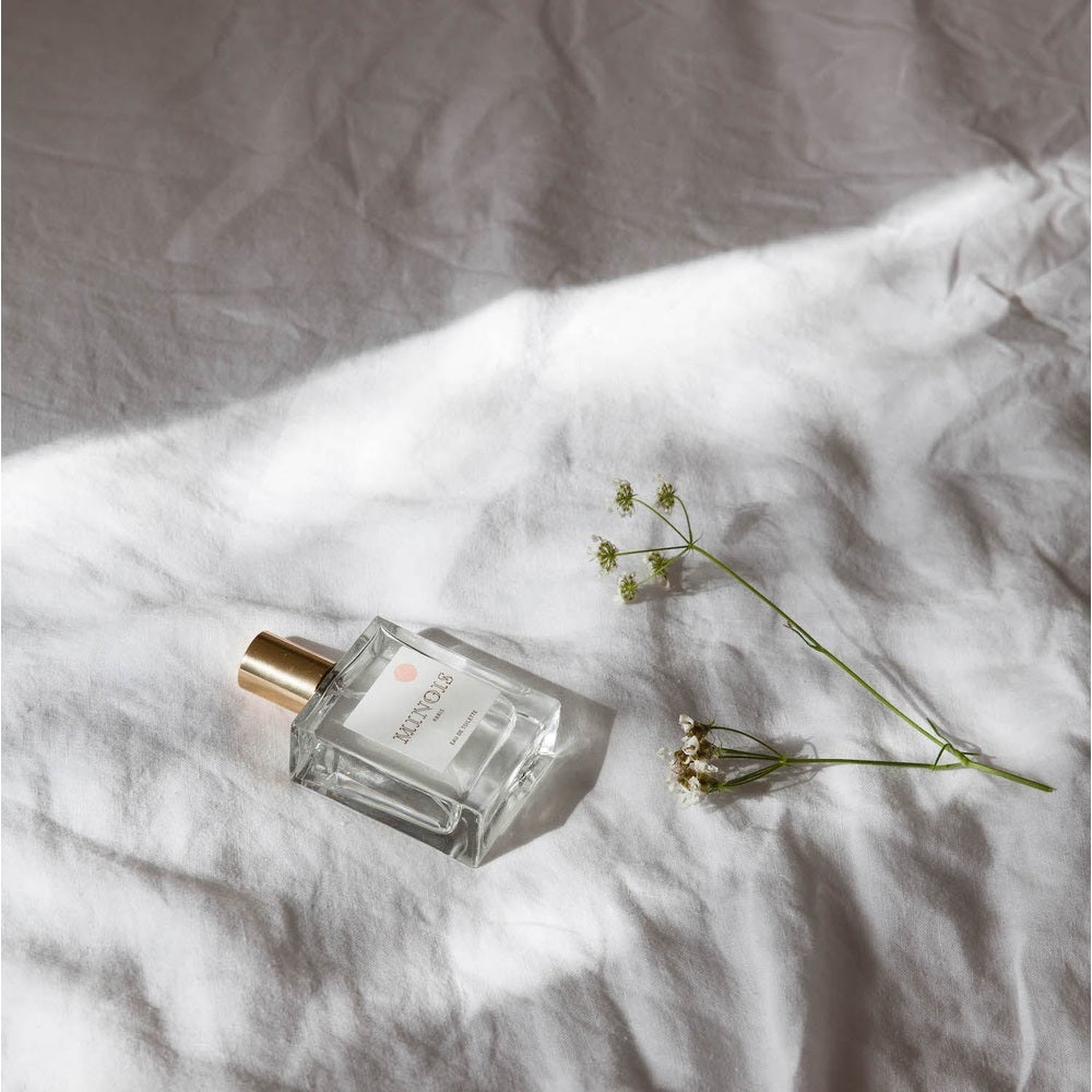 Perfume bottle by Minois Paris for kids and mum, 50 ml, clear glass with gold cap on white fabric