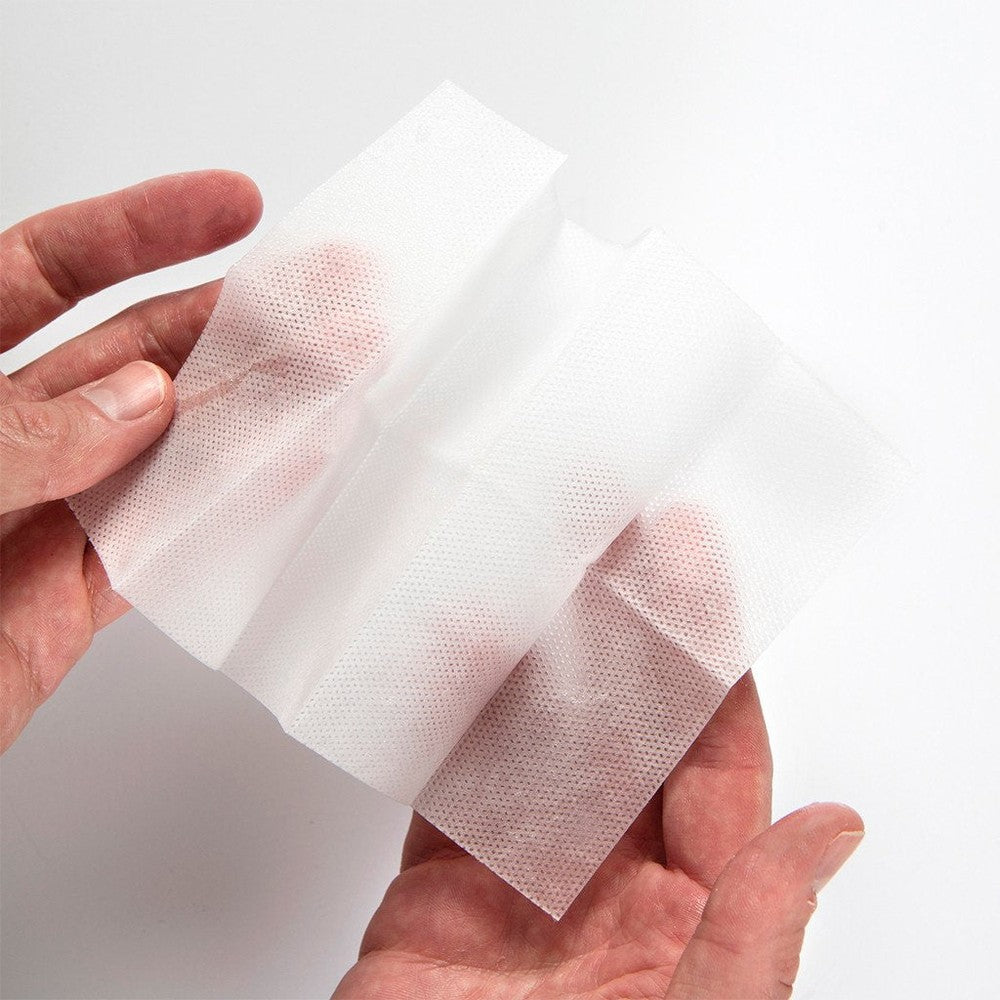 Miss Mouth's Messy Eater Stain Treater sheets being held, white disposable fabric stain-remover wipes used on messes.