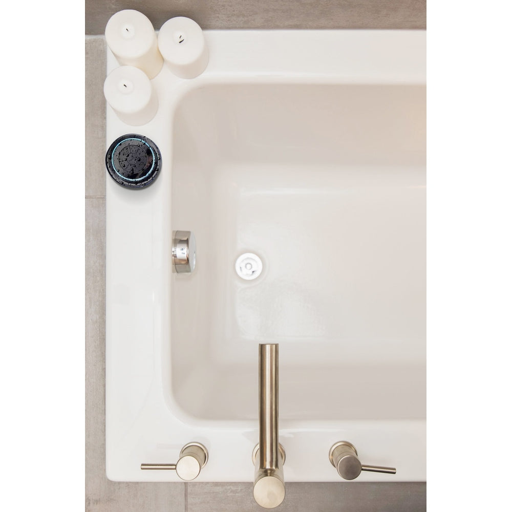 Mob Bluetooth Waterproof Speaker (black/blue) in bathroom beside tub faucet and candles, MOB brand.