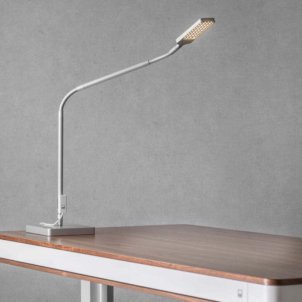 Moll L7 designer LED desk lamp with adjustable white metal neck on wood desk