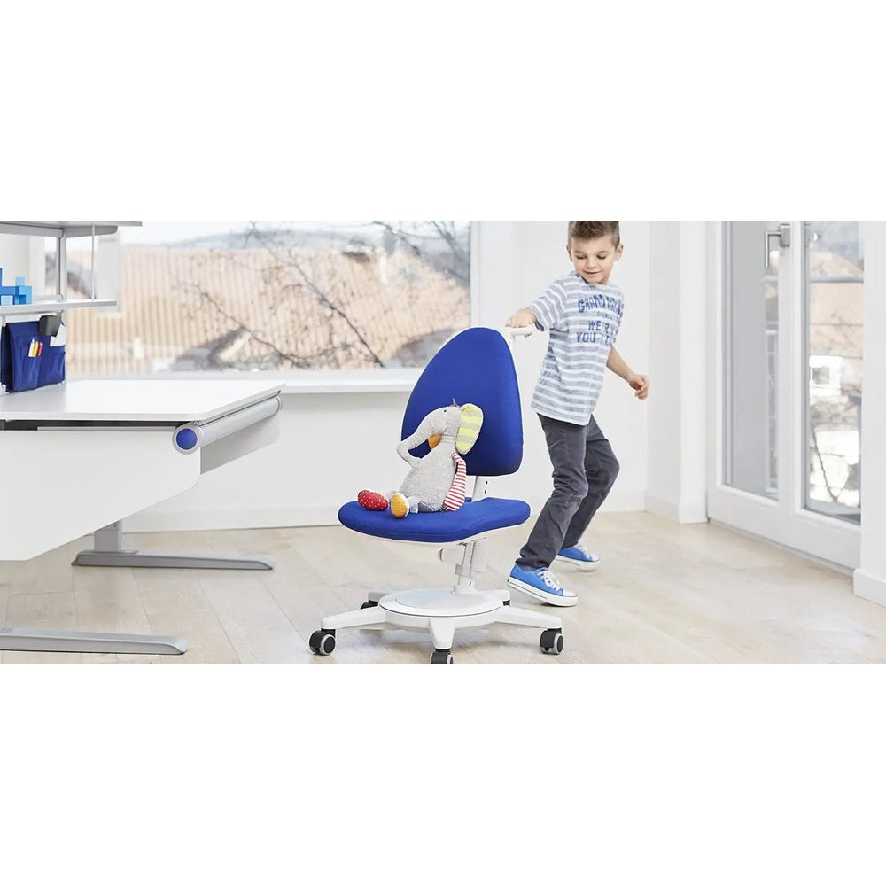 Moll Maximo Children Swivel Chair White Frame with blue upholstery; child spins the wheeled chair with a plush elephant on the seat.