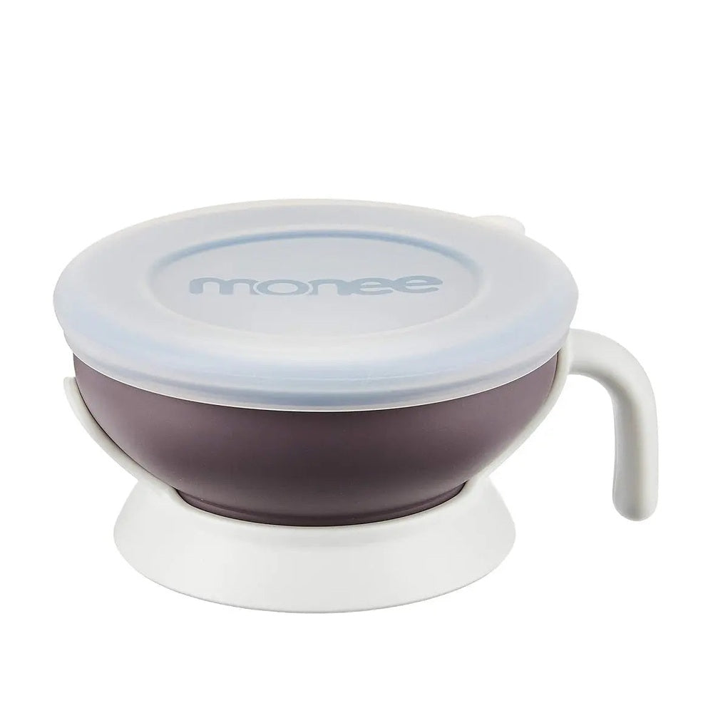 MONEE Baby Bowl 150 ml in purple with white lid, resting on a white stand for feeding.