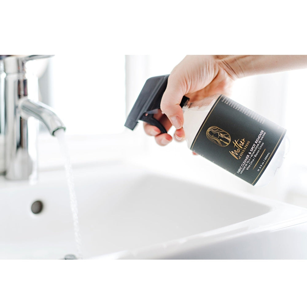 Mother Of Invention fabric cleaner and stain remover spray bottle, 500 ml, black label, held over sink