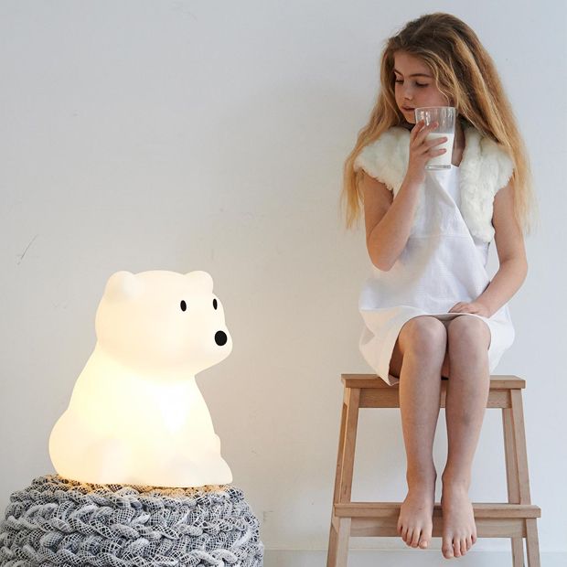 Mr Maria Nanuk table lamp polar bear night light with a warm glow beside a girl.