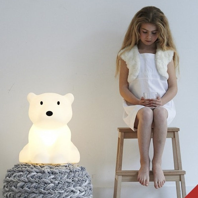Mr Maria Nanuk bear-shaped table lamp with warm glow beside a knitted pouf