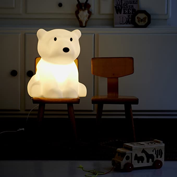 MR MARIA Nanuk bear table lamp with warm white glow on a wooden chair.