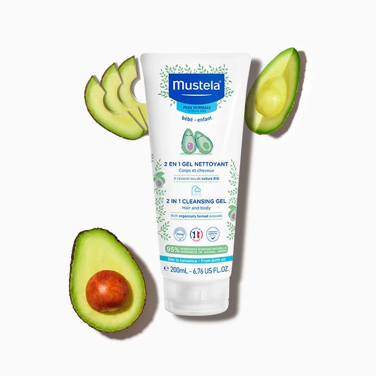 Mustela 2 In 1 Cleansing Gel with Avocado 200 ml tube, surrounded by avocado halves, for gentle hair and body cleansing.