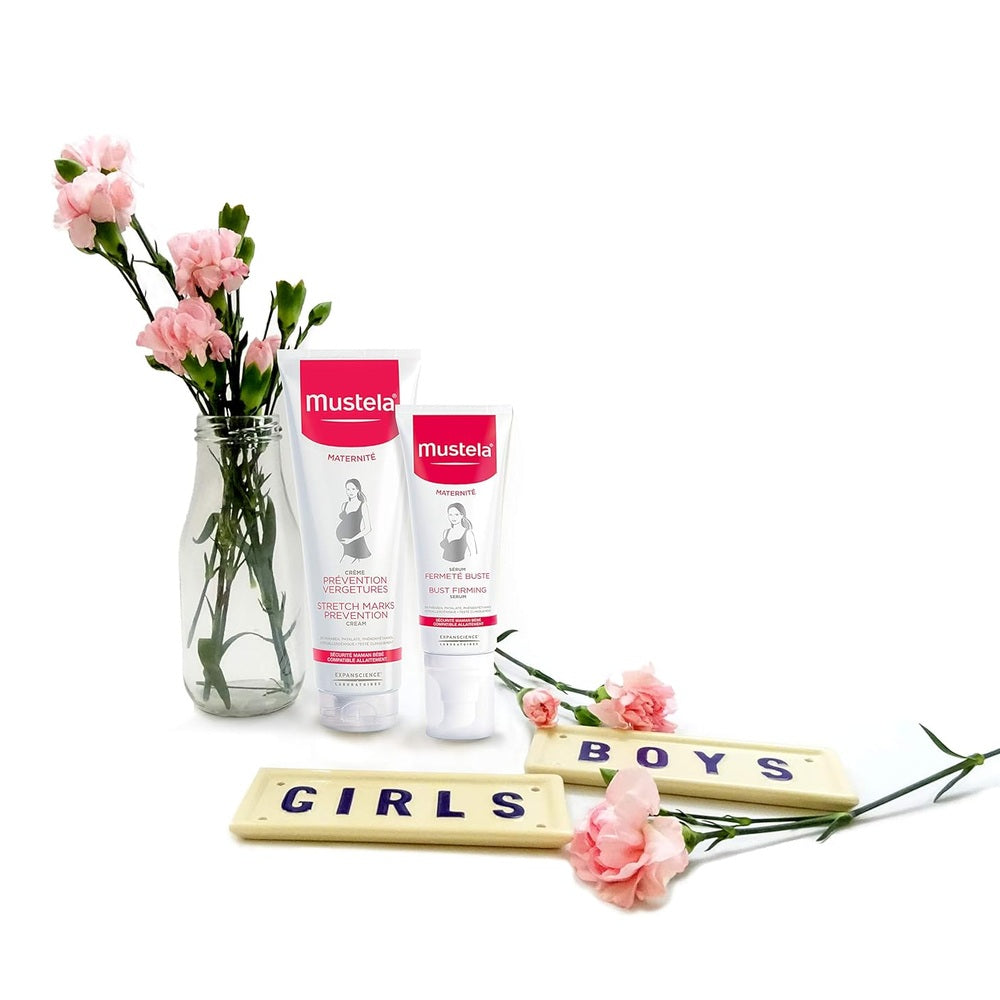 Mustela Bust Firming Serum 75 ml; two pink-labeled tubes beside a glass vase of pink carnations.
