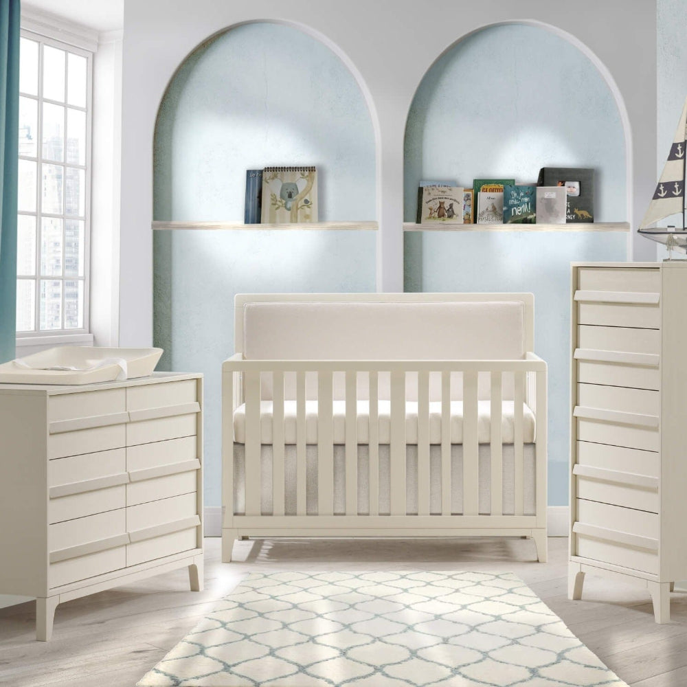 Natart Kyoto 54-inch double bed with low-profile footboard in white, shown with two white dressers in a pale blue nursery.