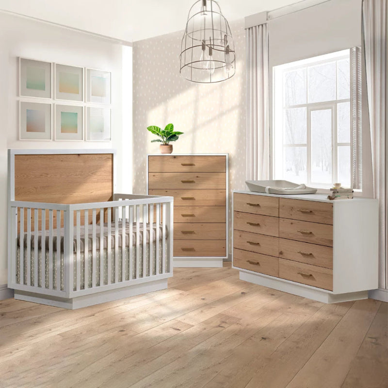 Natart Signature Series Como Naturale Nightstand in natural wood drawers with white frame beside a matching dresser in a bright nursery.