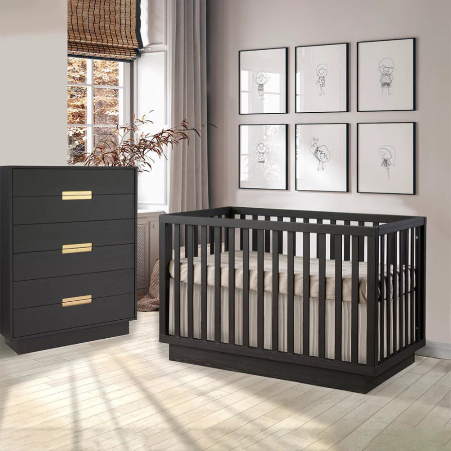 Natart Taylor Island Crib with a matching black dresser featuring gold handles in a modern nursery.