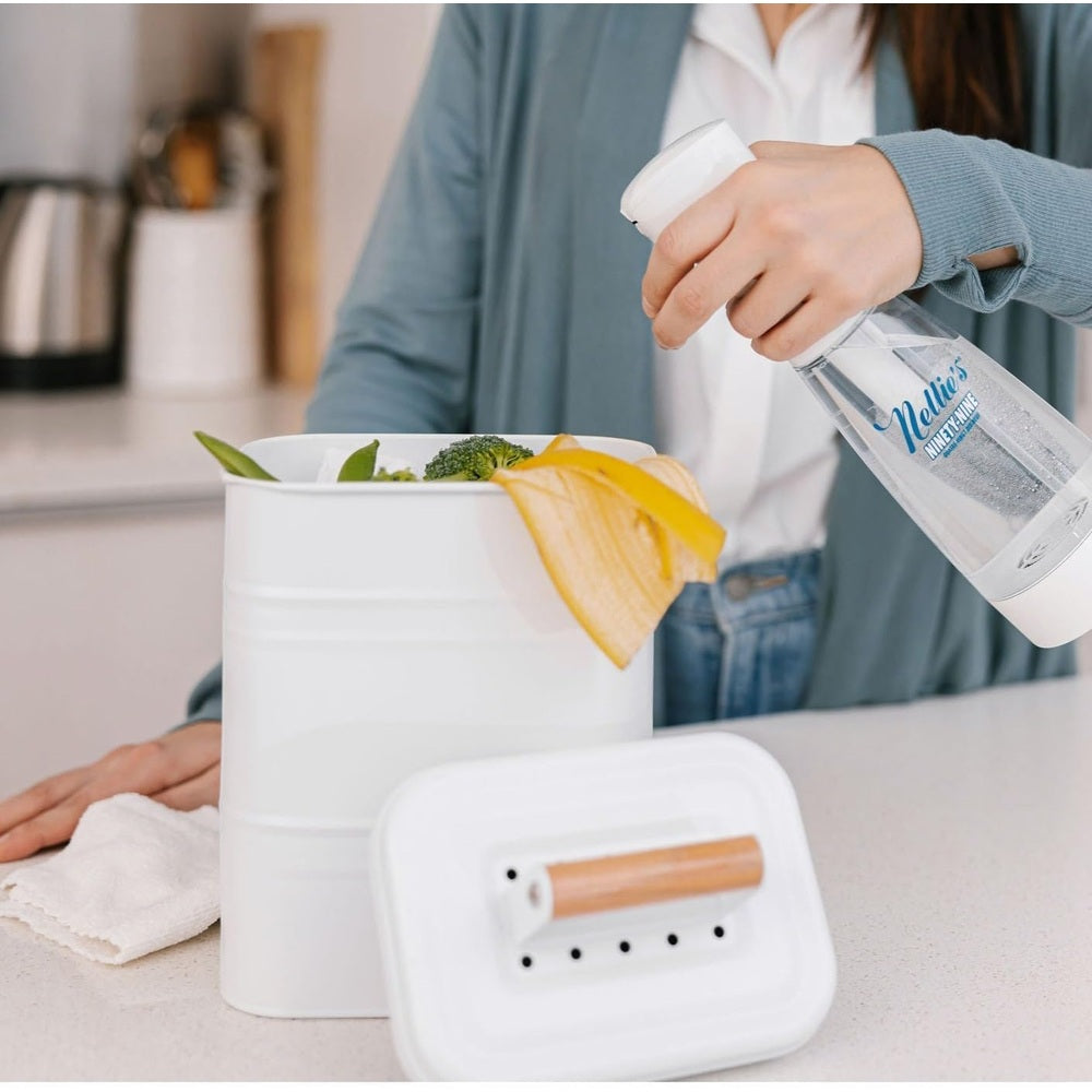Nellie's Ninety-Nine spray bottle cleaning a white bucket with a yellow towel in a kitchen