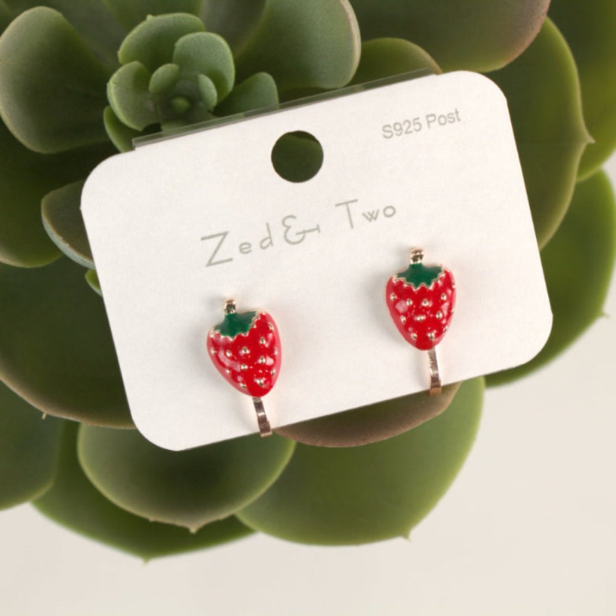 Nemibaby Earrings: two red enamel strawberry studs with green leaves on a white card, sterling silver posts.