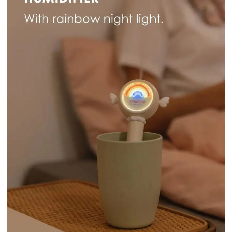 Nemibaby Rainbow Fairy Humidifier with rainbow night light perched in a mint green cup in a cozy bedroom.