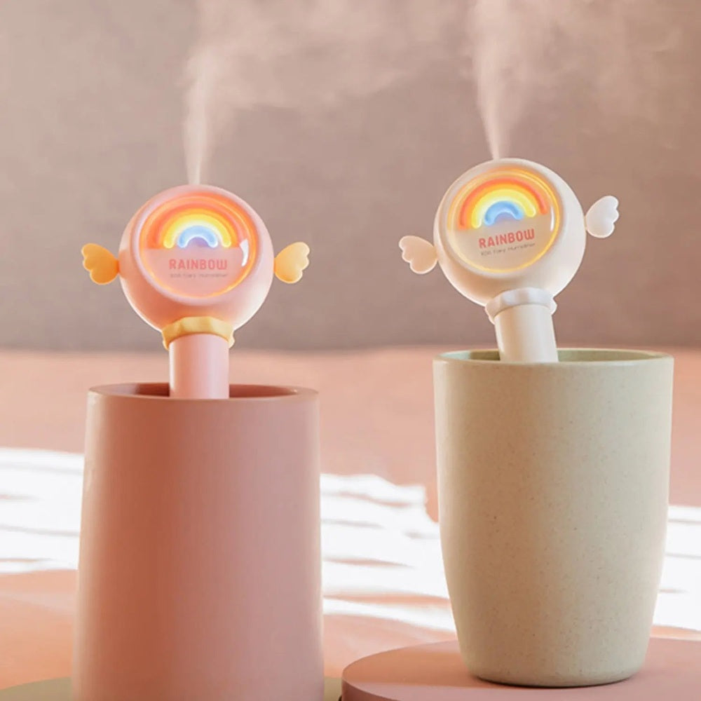 Nemibaby Rainbow Fairy Humidifier 2-pack in pastel pink/beige, both units emit mist with rainbow motif.