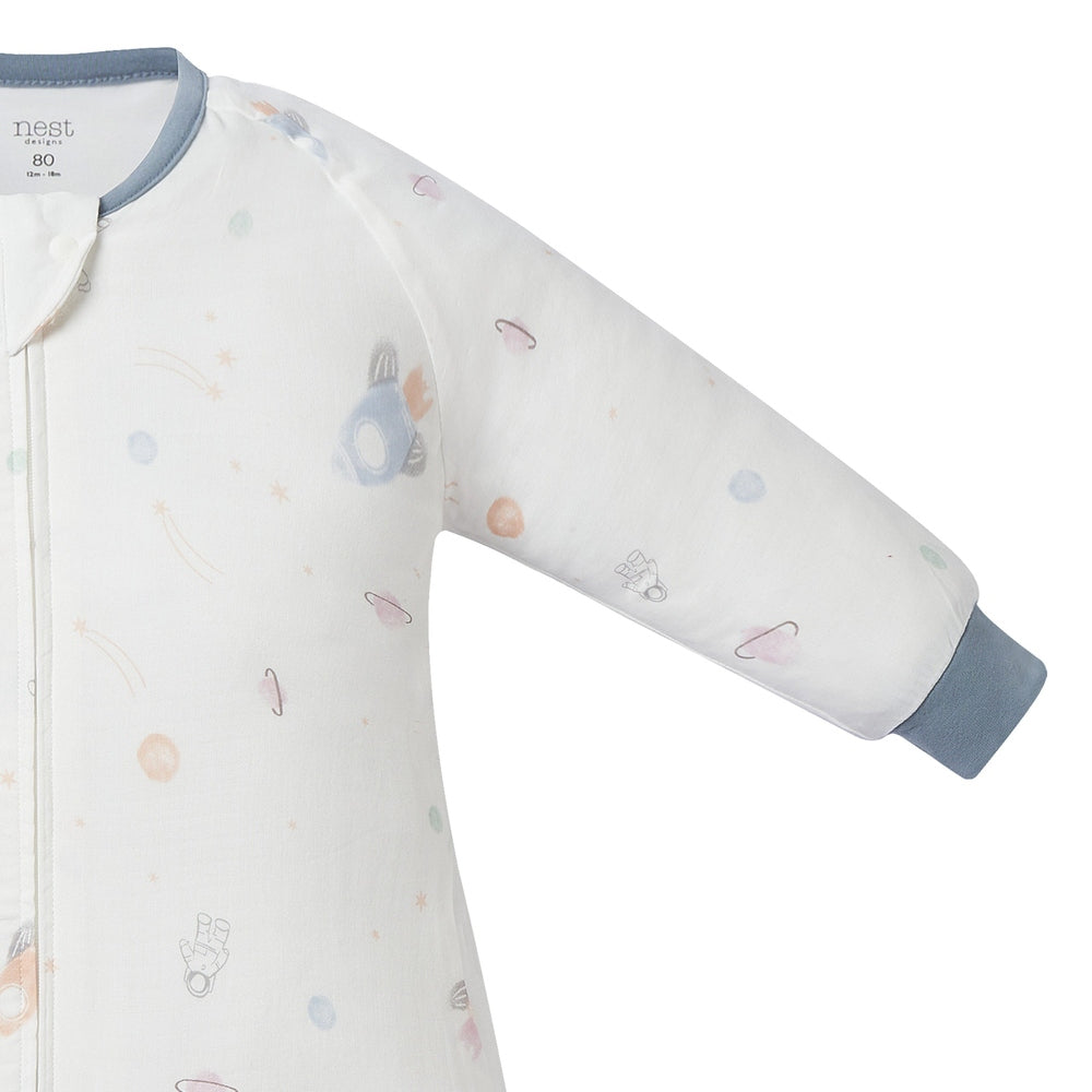 Nest Designs Avocado Bamboo Long Sleeve Footed Sleep Bag white with pastel prints and blue cuffs, baby extends arm