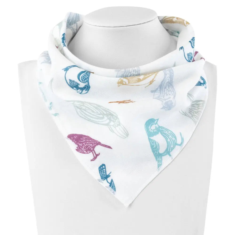 Nest Designs Bamboo Baby Bandana Bib One Size (3M-24M) white with colorful animal print shown on a display mannequin.