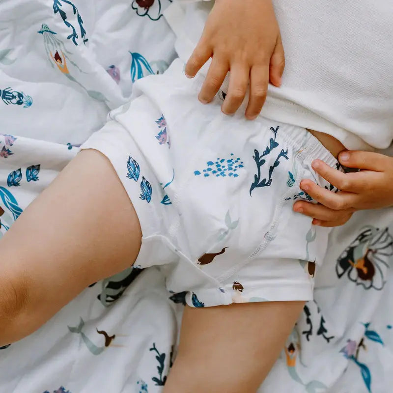 Nest Designs Bamboo Boys Boxer Briefs Underwear 2-pack, white with blue undersea print; child grips waistband showing snug elastic fit.