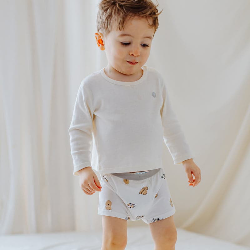 Nest Designs Bamboo Boys Boxer Briefs Underwear Savanna Secrets, white 2-pack; toddler wears safari-print briefs.