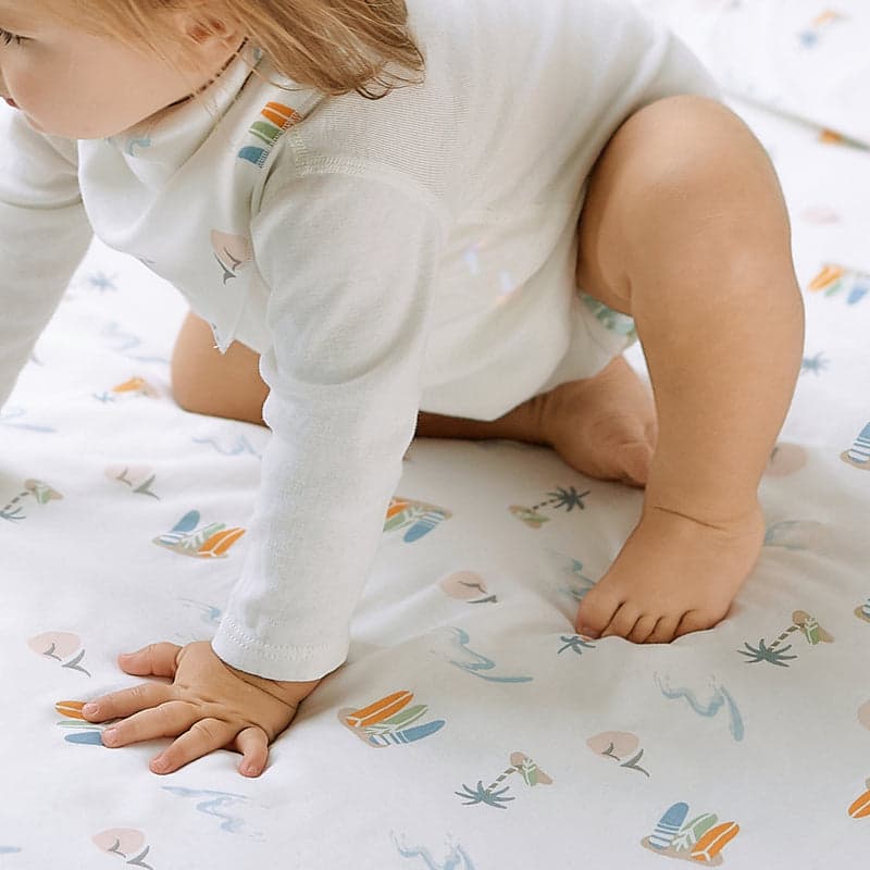 Nest Designs bamboo crib sheet pastel waves; soft white fabric with pastel sea-inspired patterns