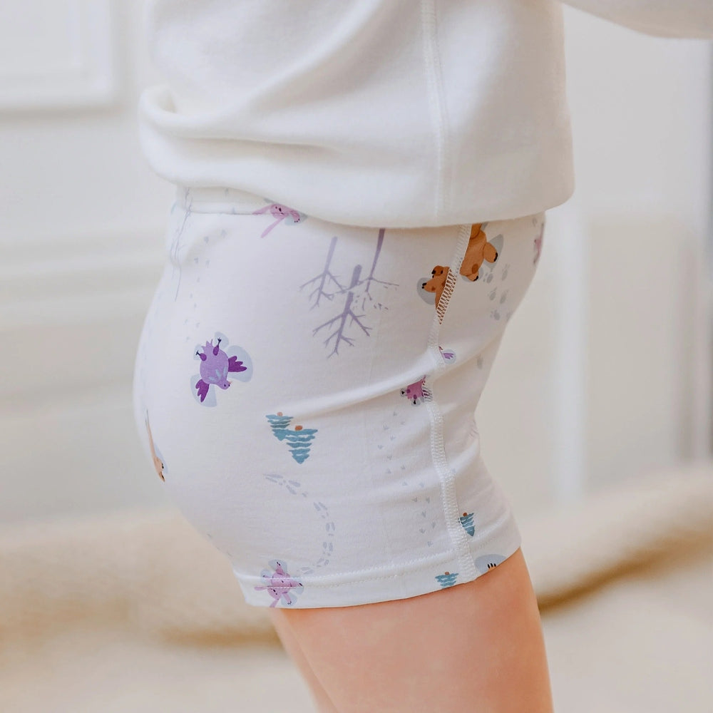 Nest Designs Bamboo Girls Boy Short Underwear Snow Buddies 2-pack, white with pale prints, shown snug under a white top.