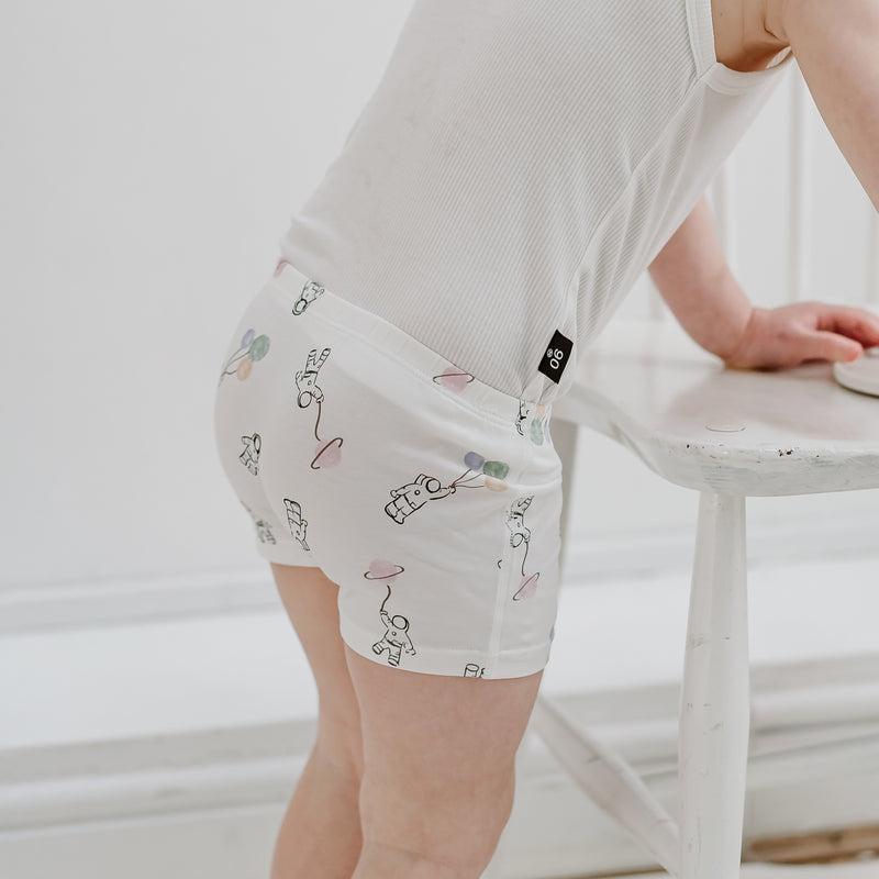 Nest Designs Bamboo Girls Boy Short Underwear 2-pack, white with astronaut illustrations, worn by a child.