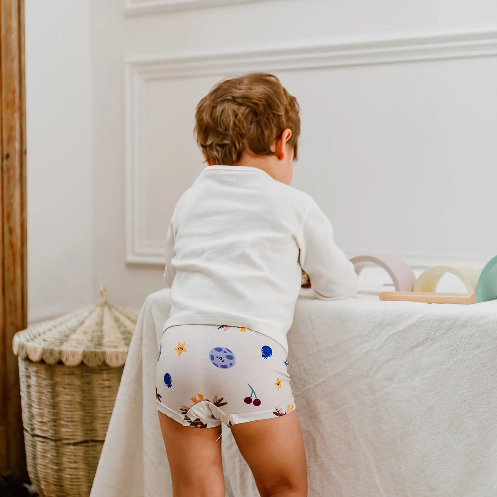 Nest Designs bamboo jersey boys boxer briefs 2-pack with space-themed prints, worn by toddler.